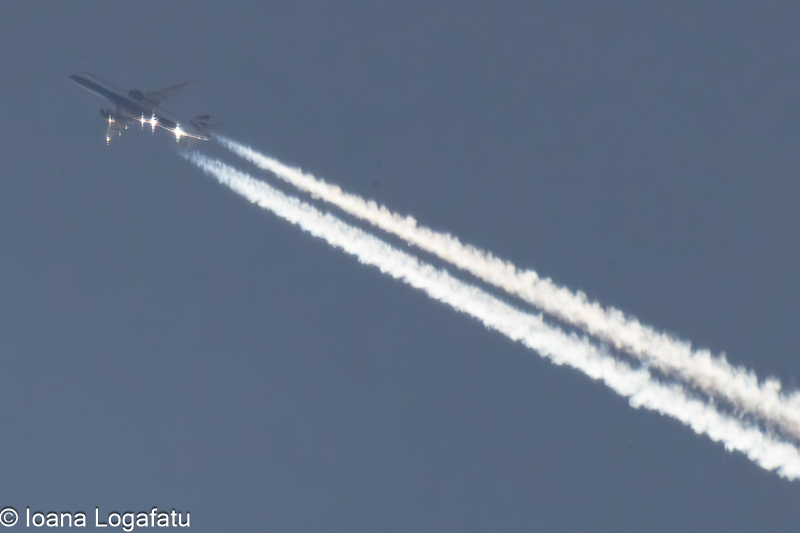 Contrails slicing through a clear blue sky above